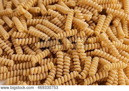Gluten Free Cornmeal Pasta Wallpaper. Spiral Raw Macaroni From Corn And Rice Flour Rotating On Turnt