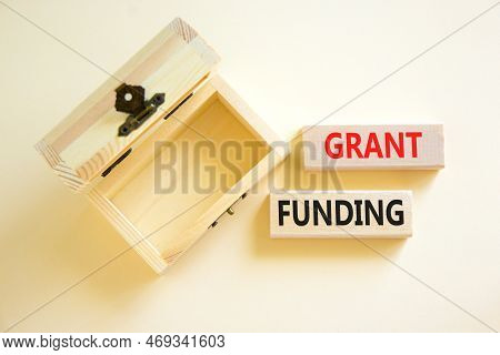 Grant Funding Symbol. Concept Words Grant Funding On Wooden Blocks. Beautiful White Table White Back