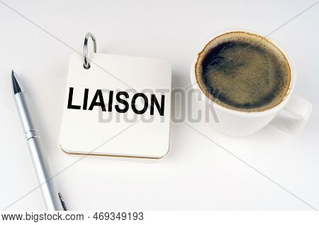 Business Concept. On A White Surface, A Cup Of Coffee, A Pen And A Notepad With The Inscription - Li