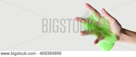 Hand Playing With Textured Slime On White Background. Teen Hand Holding Green Shining Slime With Bub