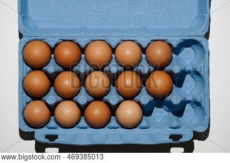 Top View Freerange Fresh Eggs In Blue Recycled Carton Crate. Farm Texture Harsh Light Closeup