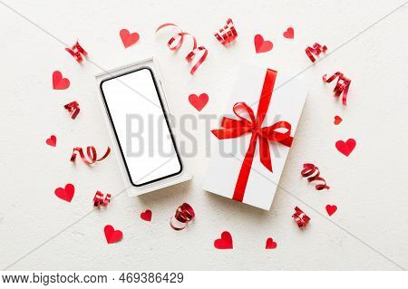 Opened Gift Box With Ribbon And Phone On Color Background, Top View. Blank Open Box Packaging Mockup