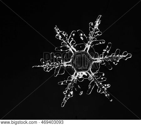 Macro Photo Of A Beautiful Snowflake Close-up On A Black Background
