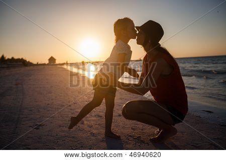 Moeder en dochter silhouet In de zonsondergang op het strand op Holbox Island