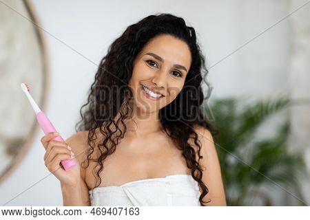 Smiling Arabic Millennial Lady In Towel With Snowwhite Perfect Teeth Hold Toothbrush, Enjoy Oral Hyg