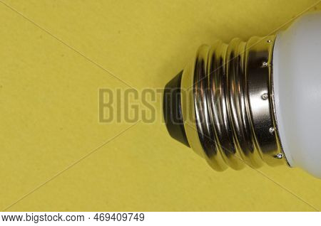 Metal Screw Base Of A Light Bulb On A Yellow Background