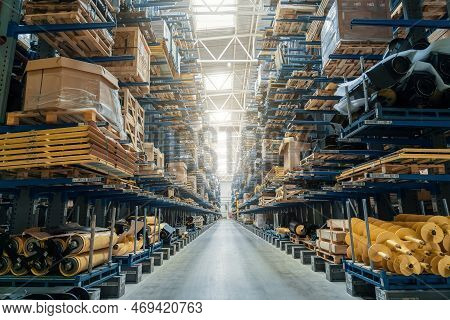 Modern Distribution Warehouse Interior With Many Goods In Boxes On Shelves.