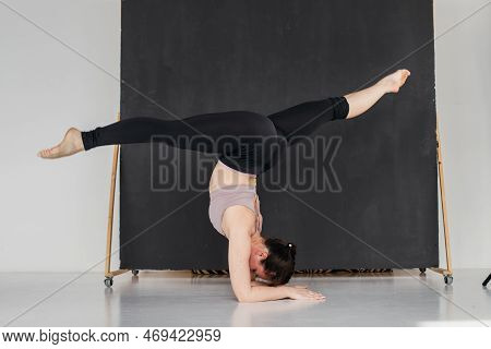 Young Professional Gymnast Woman Standing On Splits. Pretty Brunette Girl Doing An Elbow Stand. Fema