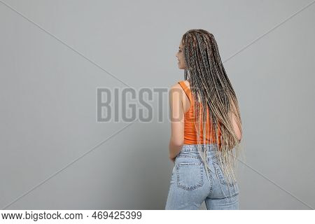 Beautiful Woman With Long African Braids On Grey Background, Back View. Space For Text