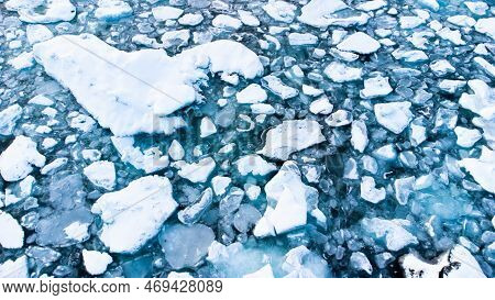 Melting Arctic Ice In Ocean Water. Blue Glacier Ice Covered With Snow In Iceland. Climate Crisis