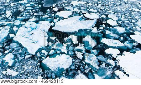 Melting Arctic Ice In Ocean Water. Blue Glacier Ice Covered With Snow In Iceland. Climate Crisis