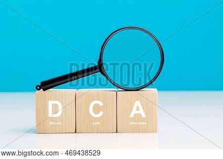 Magnifying Glass And Dca Word On A Wooden Cube In Idea Dollar Cost Averaging Investment Strategy, Sa