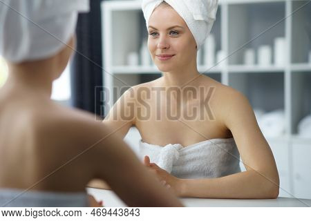Young Woman Sits In The Bathroom In Front Of The Makeup Mirror And Does Cosmetic Procedures. Beautif