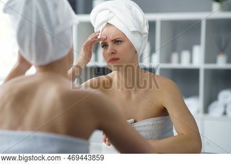 Young Woman Sits In The Bathroom In Front Of The Makeup Mirror And Does Cosmetic Procedures. Beautif
