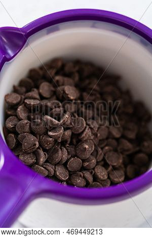Melting Chocolate Chips In A Candy Melting Pot To Make Chocolate-covered Pretzel Rods.