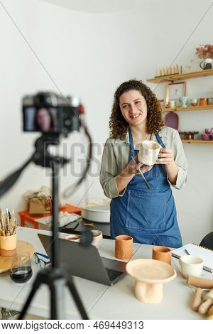 Females Potter Making A Vlog, Recording Online Course, Lessons In Her Studion With Earthenware Shelf