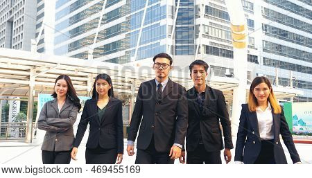 Group Of Business People Asian Team Partners Walking In City Happy Together. Leader Executive Men St