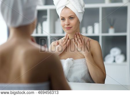 Young Woman Sits In The Bathroom In Front Of The Makeup Mirror And Does Cosmetic Procedures. Beautif