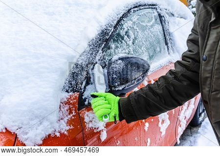 Teenager  Cleans Car After A Snowfall, Removing Snow And Scraping Ice
