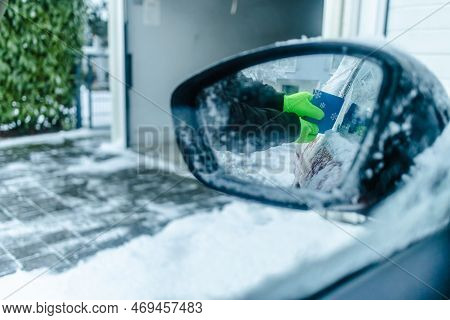 Teenager  Cleans Car After A Snowfall, Removing Snow And Scraping Ice