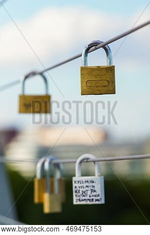 Close Up Of Lovelocks Hanging On Metal Fence