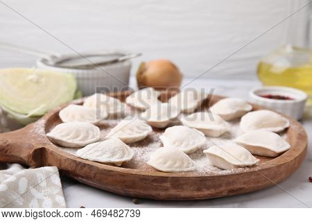 Raw Dumplings (varenyky) With Tasty Filling And Flour On Wooden Board, Closeup
