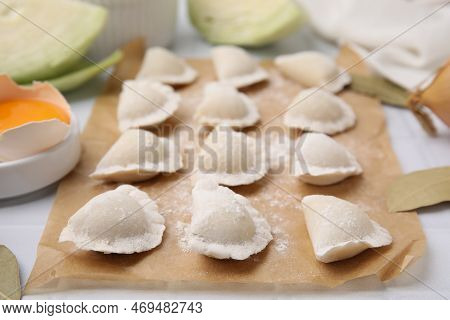 Raw Dumplings (varenyky) With Tasty Filling And Flour On Parchment Paper, Closeup