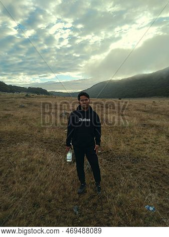 Bogor, Indonesia - 07 01 2021: A Man Standing Against The Backdrop Of The Beautiful Savanna Of Mount