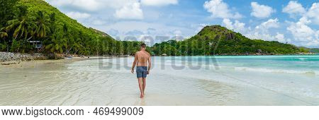 Young Tanning Men In Swim Short At A White Tropical Beach Anse Volbert Beach Praslin Seychelles