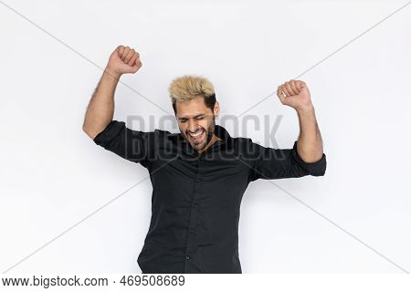 Portrait Of Excited Young Man Makig Winning Gesture Over White Background. Caucasian Guy With Stubbl