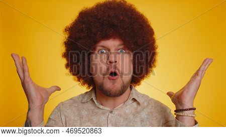 Excited Amazed Man With Lush Afro Hairstyle Coiffure In Touching Head And Showing Explosion, Looking