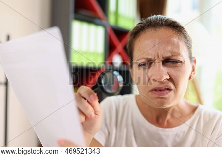 Incredulous Middle Age Woman Looking On Document Trough Magnifying Glass Close-up. Concept Of Eye Di