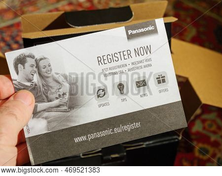 Paris, France - Dec 2, 2022: Male Hand Holding Register Now Flyer Paper During The Unboxing Of New P