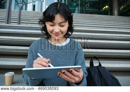 Portrait Of Asian Girl Student, Hipster Sitting On Stairs With Digital Tablet And Cup Of Coffee, Dra