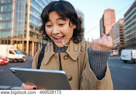 Enthusiastic Asian Girl With Digital Tablet, Smiling And Looking Amazed, Happy With Something Good, 