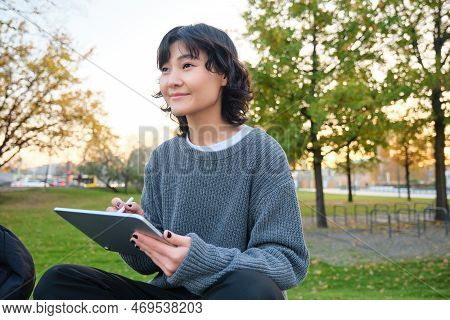 Portrait Of Young Smiling Korean Girl, Graphic Designer, Artist Drawing On Digital Tablet With A Pen