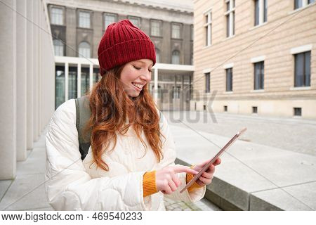 Stylish Ginger Girl, Tourist Walks With Digital Tablet Around City, Woman Connects To Iternet On Her