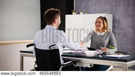 Business Man In Wheel Chair Shaking Hand In Office