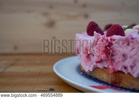 Rasperry Cake With Cream And White Chocolate On Wooden Board