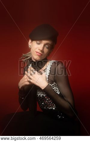 Positive Queer Model In Fashionable Outfit And Silver Rings Posing With Closed Eyes And Hands Near C