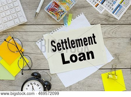 Settlement Loan . Calendar Pages And Multi-colored Paper Clips Near A Notepad With Text.