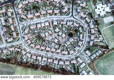 Aerial View Directly Above The Snow Covered Streets And Rooftops Of A Suburban Residential Developme