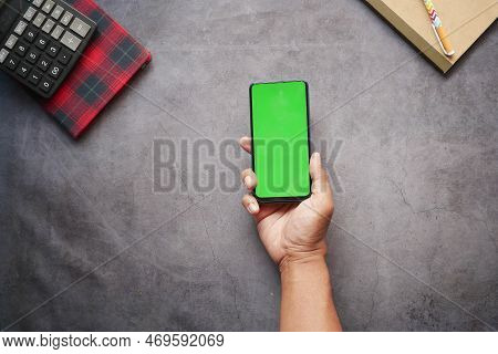 Top View Of Man Hand Using Smart Phone On Office Desk
