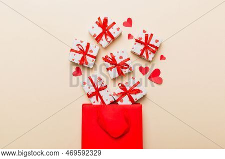 Gift Boxes Pop Out From Paper Bag Top View On Colored Background. Bag Packing Handmade Boxes Fall Ou