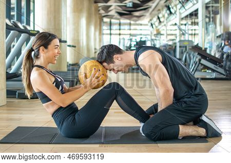 Fitness Couple Doing Exercises With A Medicine Ball At Gym.