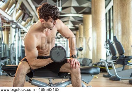 Handsome Young Man Lifting Weight At Gym.