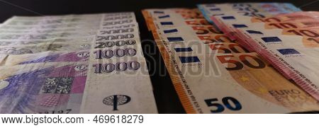View Of Czech And Euro Banknotes Stacked On Top Of Each Other, Dark Background, Photo