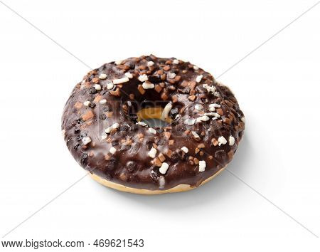 One Donut In Chocolate Glaze Sprinkled With Pieces Of White, Milk And Dark Chocolate Isolated On A W