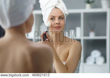 Young Woman Sits In The Bathroom In Front Of The Makeup Mirror And Does Cosmetic Procedures. Beautif