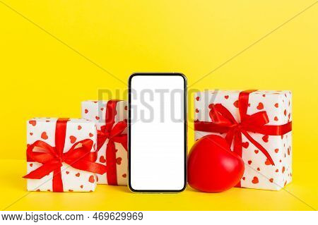 Mobile Phone With Blank Screen On Colored Background With Hearts, Calendar And Gift Box, Valentine D